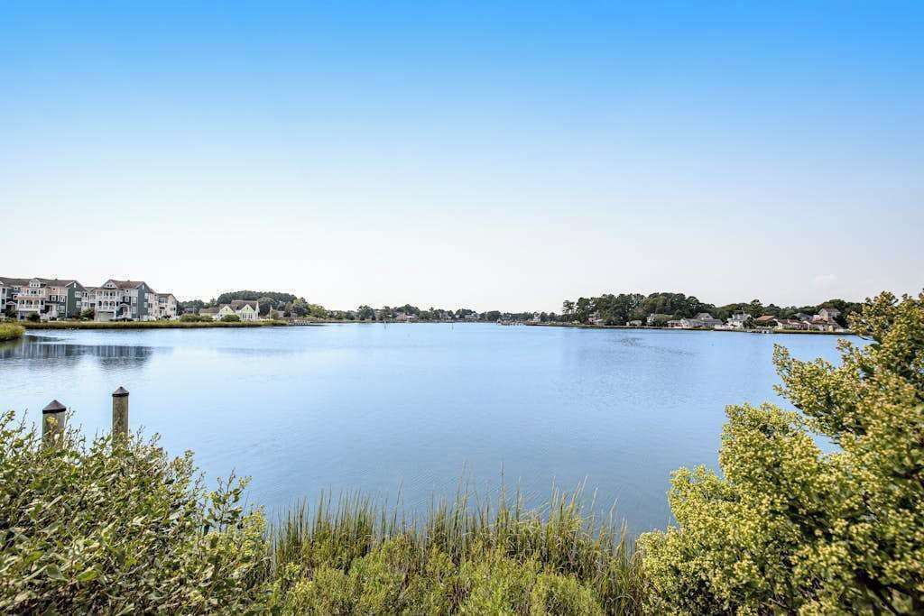 Un lago tranquilo con edificios al fondo.