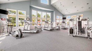 Et fitnesscenter med løbebånd, crosstrainere og styrkeudstyr.