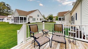 A deck with outdoor furniture, a white fence, and houses in the background. - Bear Trap Dunes Townhouse Near Bethany Beach w/Shared Pool, Free WiFi, W/D (Ocean View)