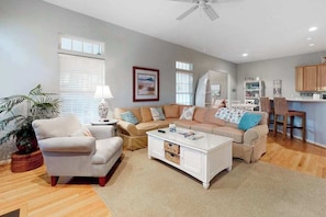 A living room with a sofa, armchairs, a coffee table, a dining area with a table and chairs, and a kitchen area with cabinets and a counter. - Lord Baltimore Landing house w/shared pool, free WiFi, central AC, private W/D (Ocean View)