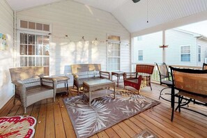 A covered porch with wicker furniture, a patterned rug, and a view of a white house. - Lord Baltimore Landing house w/shared pool, free WiFi, central AC, private W/D (Ocean View)