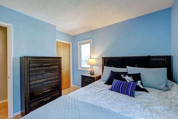 A bedroom with a bed, dresser, nightstand, lamp, and window. - Dog-friendly home close to the beach w/balcony, fireplace, grill, AC (Bethany Beach)