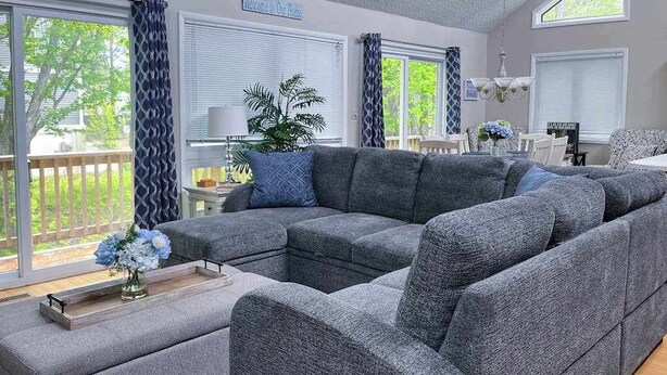 A living room with a sectional sofa, a coffee table, and a potted plant. - Dog-friendly home close to the beach w/balcony, fireplace, grill, AC (Bethany Beach)