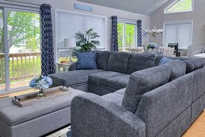 A living room with a sectional sofa, a coffee table, and a potted plant. - Dog-friendly home close to the beach w/balcony, fireplace, grill, AC (Bethany Beach)