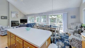 A spacious living area with a large island, a dining table, and a view of the outdoors. - Dog-friendly home close to the beach w/balcony, fireplace, grill, AC (Bethany Beach)