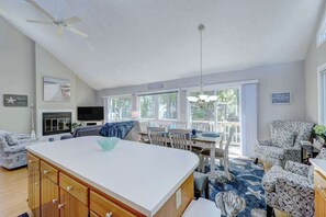 A spacious living area with a large island, a dining table, and a view of the outdoors. - Dog-friendly home close to the beach w/balcony, fireplace, grill, AC (Bethany Beach)