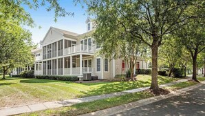 A two-story house with a porch, a garage, and a lawn. - Bear Trap Dunes 1st floor condo w/ central AC, private W/D, and gas fireplace (Ocean View)