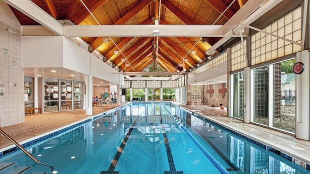 An indoor swimming pool with a high ceiling and large windows. - Bear Trap Dunes 1st floor condo w/ central AC, private W/D, and gas fireplace (Ocean View)