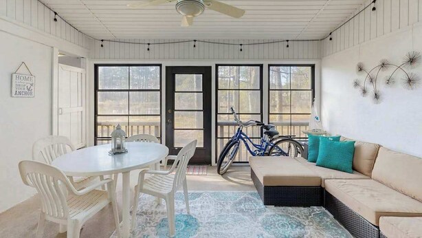 Una habitación con ventilador de techo, una mesa de comedor con sillas, un sofá y una bicicleta.