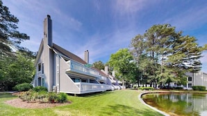 Ein modernes mehrgeschossiges Haus mit gepflegtem Rasen und einem Teich.
