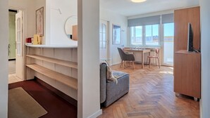 Un interno moderno con angolo cottura, zona pranzo e salotto con divano e poltrone.