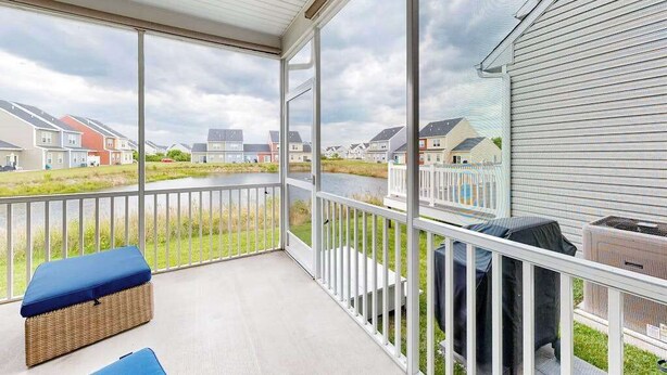 Ein überdachter Balkon mit Blick auf Häuser und ein Gewässer.
