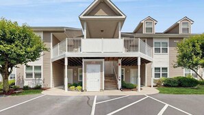Un immeuble à plusieurs étages doté d’une entrée abritée, d’un balcon et d’un parking.