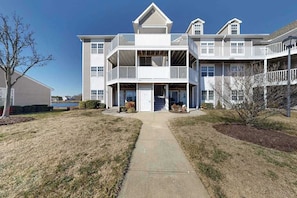 A multi-story building with a central entrance, balconies, and a covered walkway. - 1st-floor Bethany Bay condo with bay views & on-site golf/pool/tennis (Ocean View)