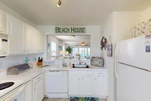 A kitchen with white cabinets, a toaster, a sink, and a refrigerator. - 1st-floor Bethany Bay condo with bay views & on-site golf/pool/tennis (Ocean View)