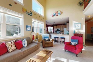 A living room with a sofa, armchairs, a coffee table, and a kitchen in the background. - Wedgefield House in Ocean View w/Private Washer/Dryer, Free WiFi, Shared Pool (Ocean View)