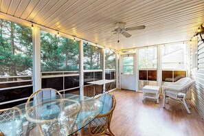 A covered outdoor area with a glass table, wicker chairs, and a ceiling fan. - Salt Pond home with on-site golf, indoor/outdoor pools, gym, & sports courts (Bethany Beach)