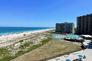 A resort with a beach view, a pool area with umbrellas, and a large building. - Sea Colony Oceanfront 6th floor condo w/free WIFI, pool & balcony w/ocean view (Bethany Beach)