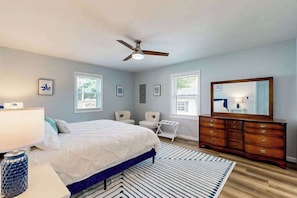 A bedroom with a bed, dresser, ceiling fan, and windows. - Mill Run Estates home w/free WIFI, W/D, just minutes to the beach (Ocean View)