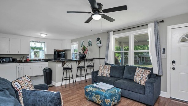 A modern kitchen with white cabinets, a black countertop, and a ceiling fan. - Hibiscus Hideaway | Relaxing 3BR Escape (Columbia)