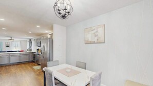 Una cucina moderna con mobili grigi, un piano di lavoro in marmo bianco e un forno integrato.