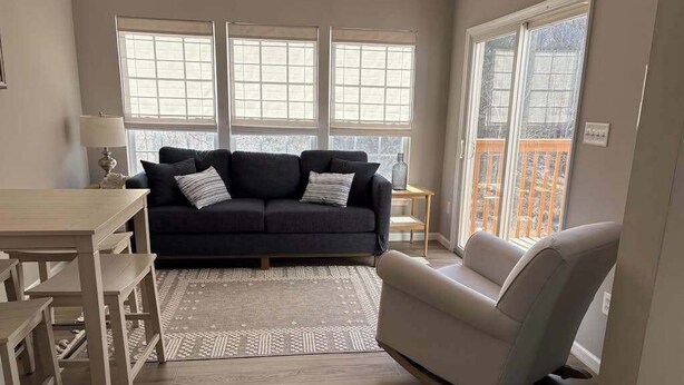 Una sala de estar con sofá, sillón y mesa de comedor.