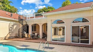 A residential property with a swimming pool, outdoor patio, and a second-story balcony. - Town of Ocean View pet friendly house with a private pool! (Bethany Beach)