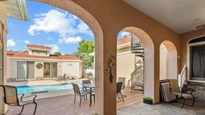 A covered outdoor area with a pool, chairs, and a staircase. - Town of Ocean View pet friendly house with a private pool! (Bethany Beach)