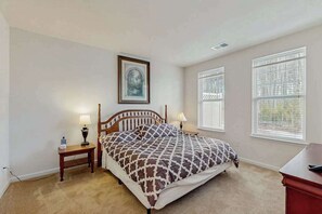 A bedroom with a bed, two bedside tables with lamps, a framed picture on the wall, and two windows with blinds. - Friendship Creek Spacious pet friendly townhome w/shared pool (Frankford)
