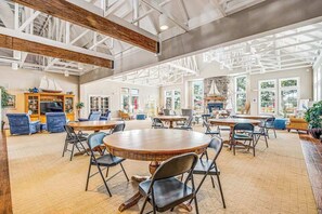 Um espaço interno amplo, com pé direito alto, grandes janelas e diversas opções de assento.