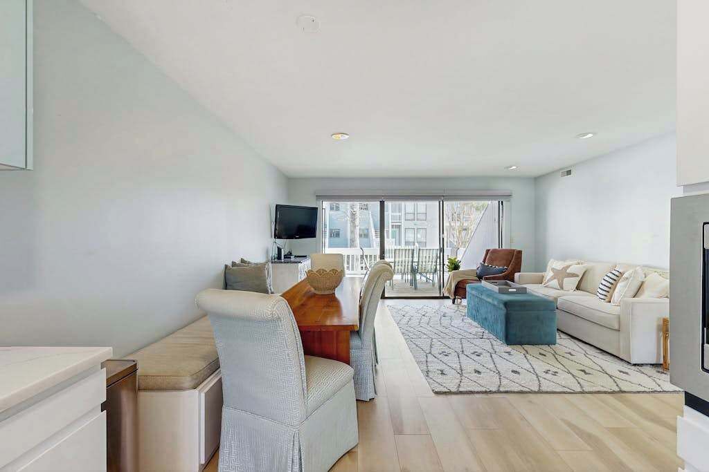 A modern living room with a dining area, a sofa, a coffee table, and a TV.