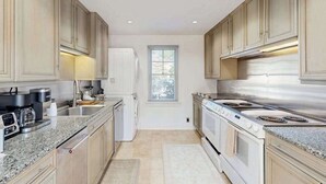 A modern kitchen with granite countertops, stainless steel appliances, and light wood cabinetry. - Town of Rehoboth Beach - 38242 Robinson Dr. Unit #1 (Rehoboth Beach)