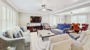 A spacious living room with a flat-screen TV, multiple seating areas, and ceiling fans. - Town of Rehoboth Beach - 38242 Robinson Dr. Unit #1 (Rehoboth Beach)