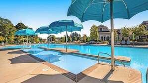 A swimming pool with multiple umbrellas, lounge chairs, and a clear sky. - Ocean View Beach Club townhome with WiFi, private patio, shared pool, & sauna (Ocean View)