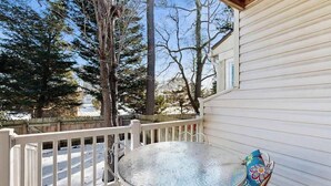 A covered outdoor area with a metal table and chairs, a white railing, and snow on the ground. - Bethany Pines townhouse w/community pool & tennis, close to beach (Bethany Beach)