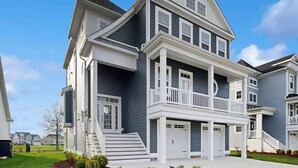 Un edificio residenziale a più piani con un balcone, un garage e un ingresso principale.