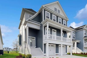 Un immeuble résidentiel à plusieurs étages, doté d’un balcon, d’un garage et d’une entrée principale.