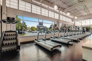 A gym with treadmills, a stair climber, and large windows. - Oceanfront complex with beach access & charm - pools, tennis, fitness centers (Bethany Beach)