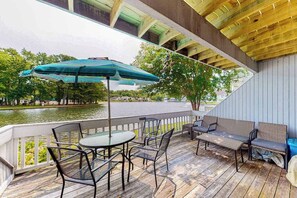An outdoor deck with a table and chairs, a bench, and a green umbrella. - Sea Colony - 33577 West Lake View, Unit 1006B | Condo in Bethany Beach (Bethany Beach)