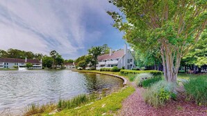 Une propriété située au bord d’un lac, comprenant une maison, un étang et de la verdure environnante.