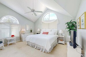 A bedroom with a bed, two bedside tables, a ceiling fan, and a TV. - Cat Hill - Inviting retreat with fireplace, lovely porch, kayaks & firepit (Bethany Beach)