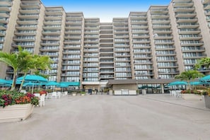 A multi-story hotel with balconies, outdoor seating, and a central courtyard. - Sea Colony Oceanfront Penthouse - Views, Wrap-Around Deck, Pools, Private Beach (Bethany Beach)
