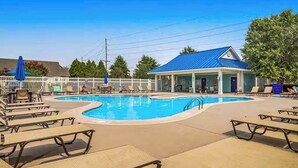 A pool area with lounge chairs, a small building with a blue roof, and a white fence. - Newly remodeled - dog friendly townhome with pools, tennis, washer/dryer & AC (Millville)