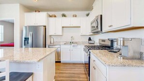 A modern kitchen with white cabinets, stainless steel appliances, and granite countertops. - Newly remodeled - dog friendly townhome with pools, tennis, washer/dryer & AC (Millville)