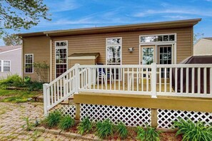 A two-story house with a front deck, a covered porch, and a small garden area. - South Hampton home with shared pool, game room, & water view- dog-friendly (Ocean View)