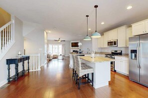 A spacious kitchen with a central island, white cabinetry, and stainless steel appliances. - Sandy Cove Townhouse w/ Water Views & Shared Pool, Private W/D, Free Wifi (Ocean View)