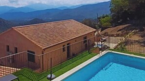 A swimming pool with a view of distant mountains, a fenced area, and a building with a tiled roof. - Top of villa Panoramic view with private pool (Moltifao)