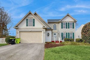 A two-story house with a garage, a front porch, and a well-maintained lawn. - South Hampton house with shared community pool & tennis courts (Ocean View)
