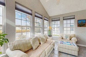 A room with a large window, a sofa, a chair, and a lamp. - South Hampton house with shared community pool & tennis courts (Ocean View)