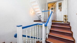 Una escalera con barandillas blancas y escalones de madera.